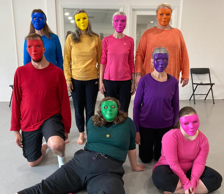 Dancers posed in rainbow colored shirts and masks